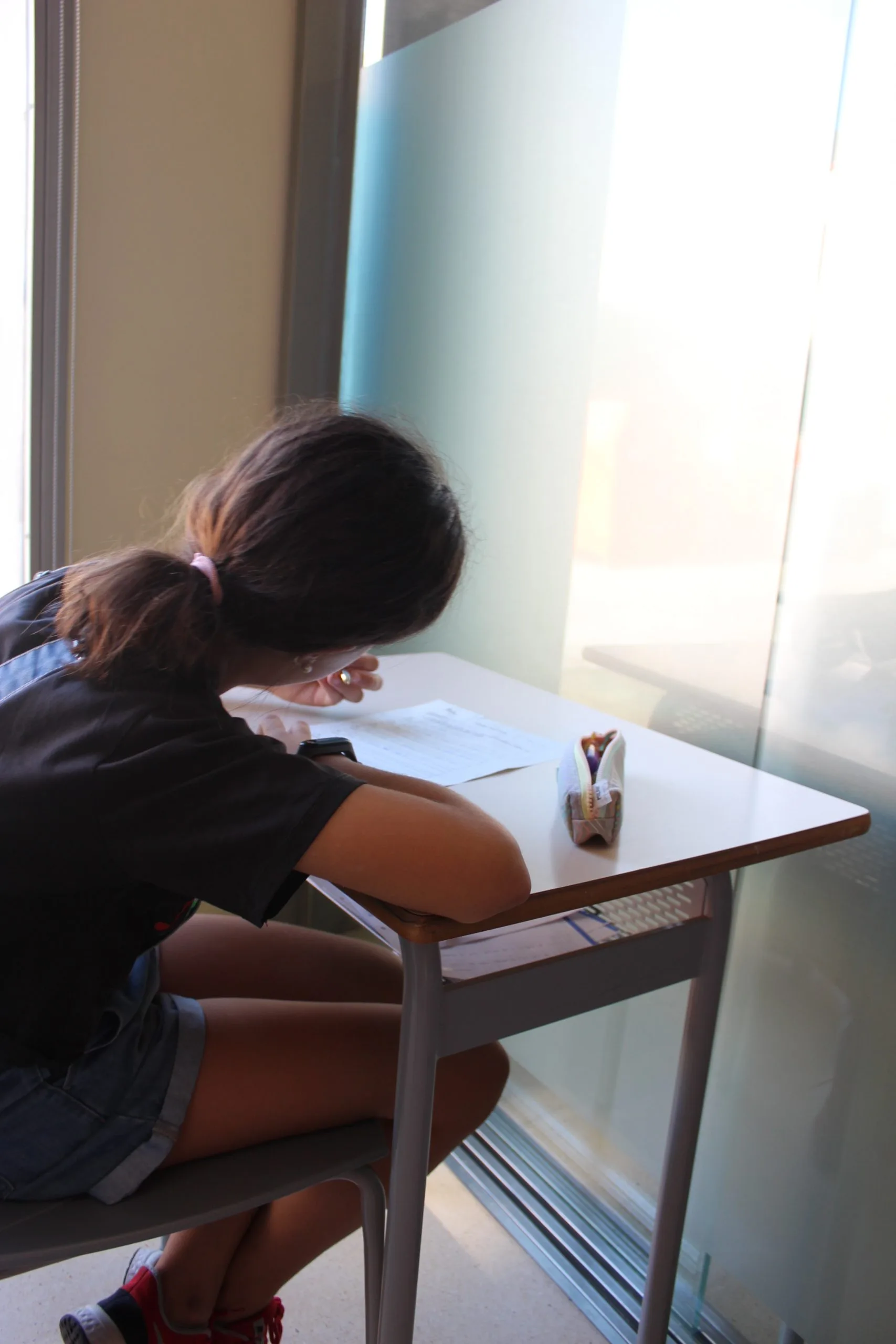 Chica escribiendo en pupitre